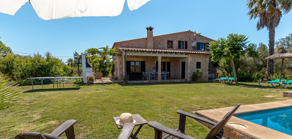 Garden with private pool and chill-out area with loungers and chairs, perfect for enjoying the sun in Mallorca.