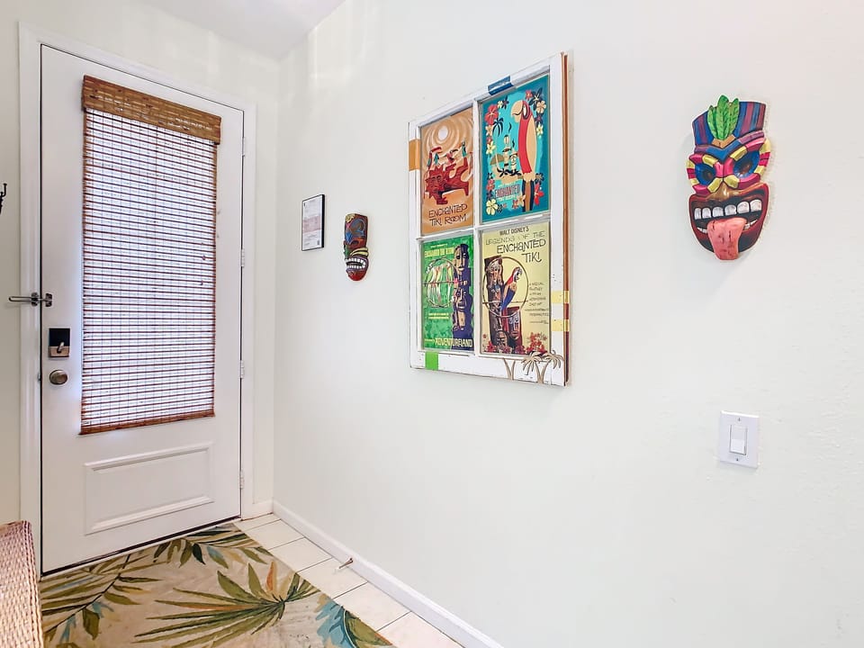 Hallway adorned with vibrant artwork and tropical touches.