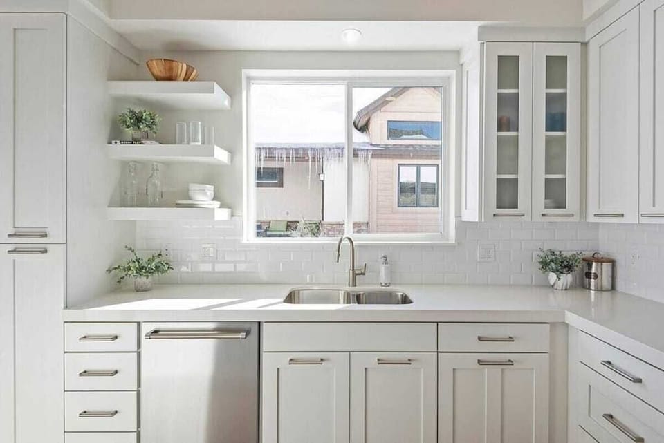 With its modern lighting, windows, quartz countertops, and stunning backsplash, the kitchen makes preparing dinner a truly enjoyable experience.