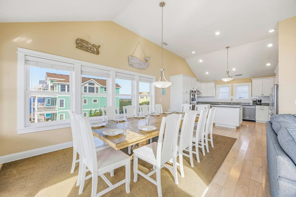 Your open-concept kitchen and dining space flows beautifully, with coastal views through large windows creating the perfect backdrop for memorable meals.