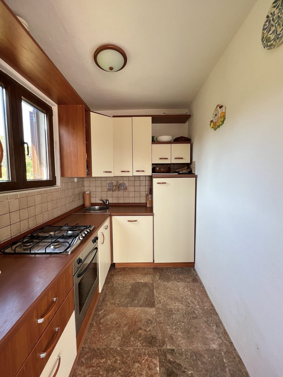 Kitchen with hob, oven, fridge, and dishwasher.
