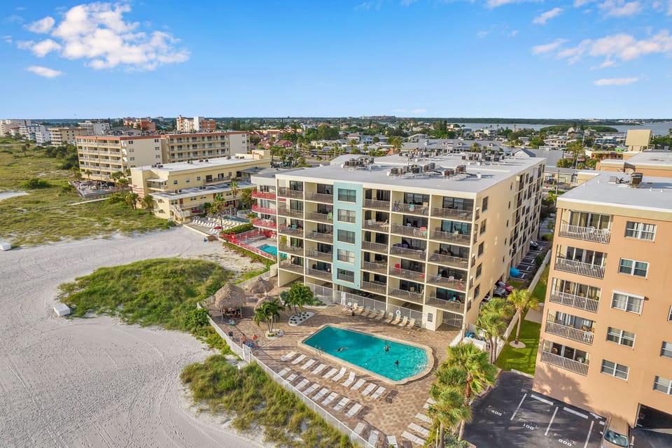 Drone shot of the condo complex with pool on the beachside 