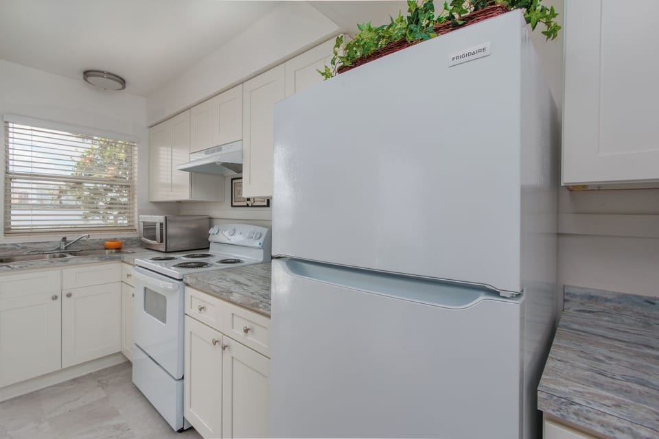 Fully equipped kitchen with modern appliances and basic cooking utensils