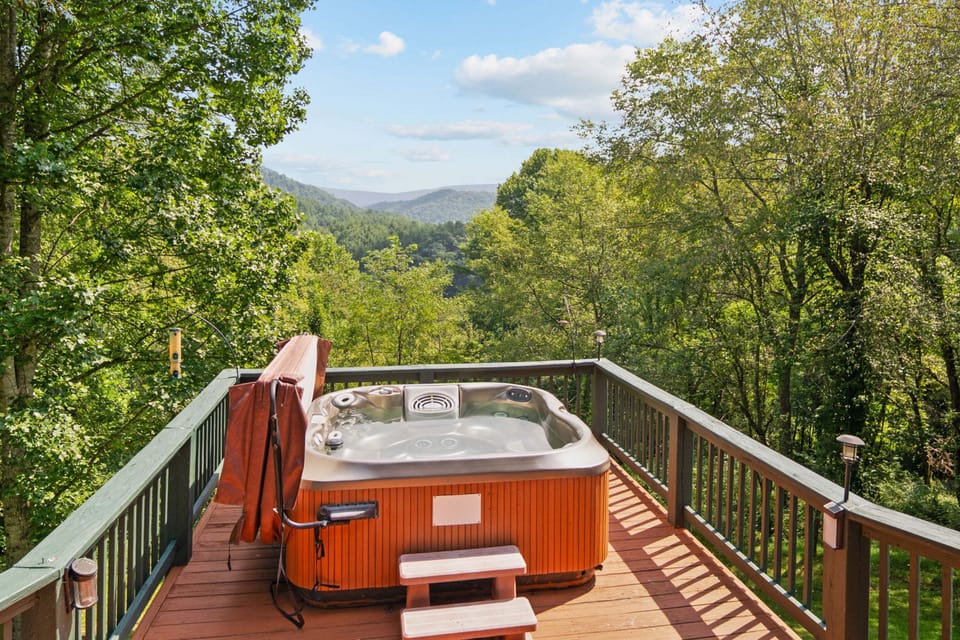 Private hot tub on the deck overlooking mountain and valley views