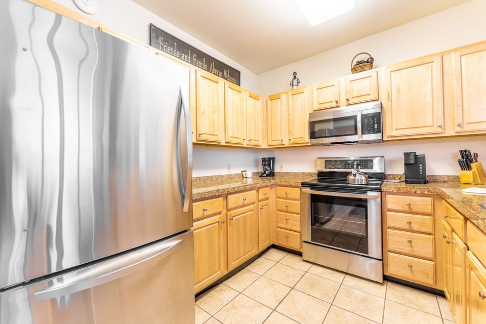 Your fully equipped kitchen awaits with stainless steel appliances, warm wood cabinets, and granite countertops for memorable meal prep.