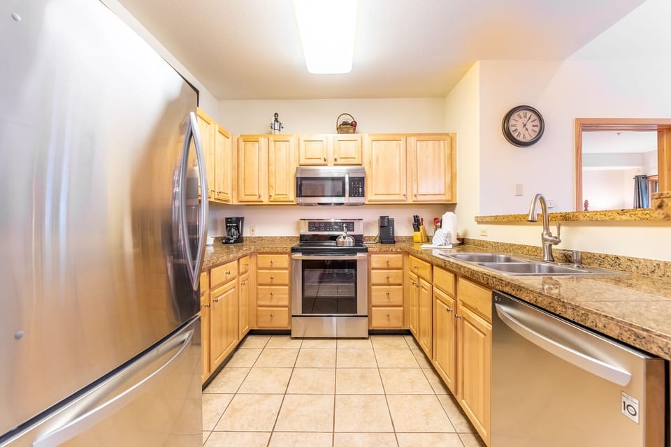 Your fully equipped kitchen invites culinary adventures with granite countertops, stainless steel appliances, and warm wood cabinets creating the perfect cooking space.