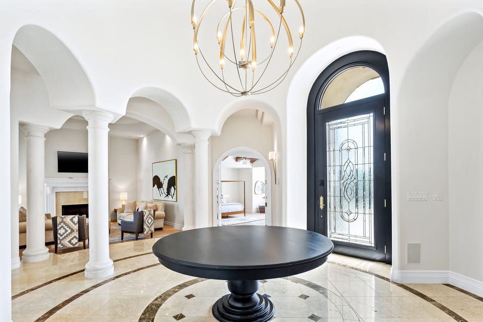 Enter through a beautiful foyer with artistic chandelier and sweeping open views
