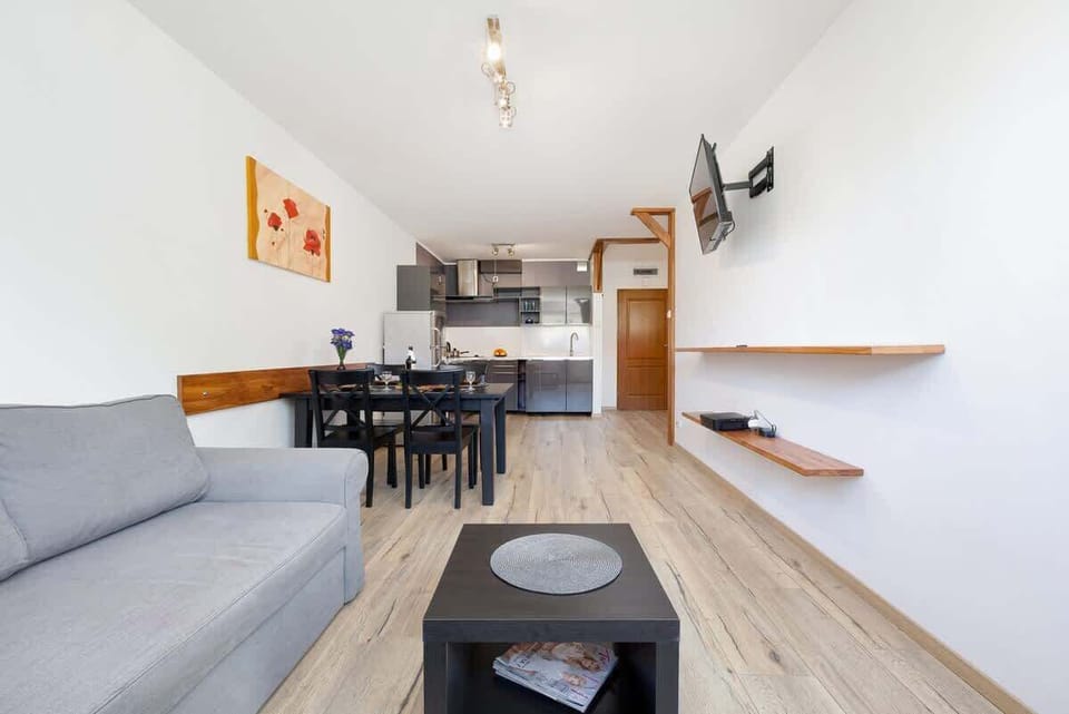 Another view of the living room, showcasing the dining area and a painting on the wall adding a pop of color.