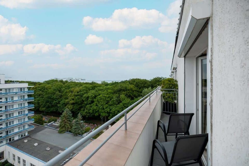 A view of the balcony with outdoor seating, offering a great place to relax while enjoying the surrounding greenery.