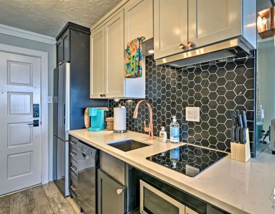 The kitchenette features a refrigerator, dishwasher, microwave, Keurig and a cooktop single cup coffee maker