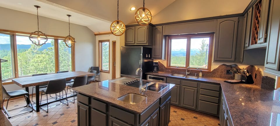 Full kitchen with JennAir cooktop, quartz countertops, and double ovens.