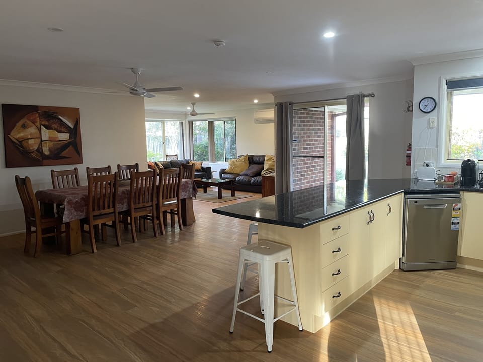 View from kitchen through to dining and rumpus, patio sliding door to right.
