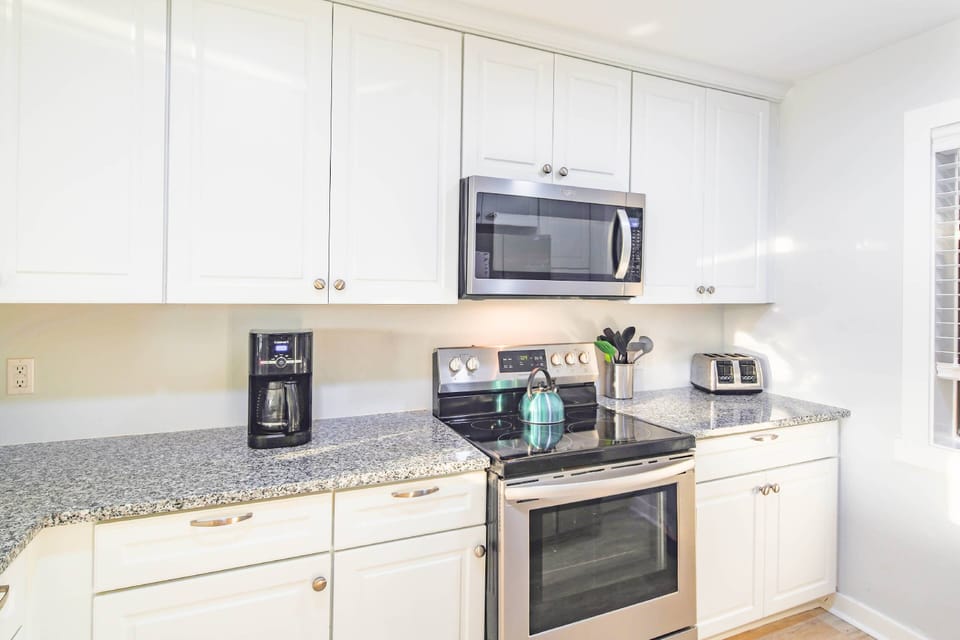 The kitchen features an electric range, microwave, toaster and drip coffee maker.