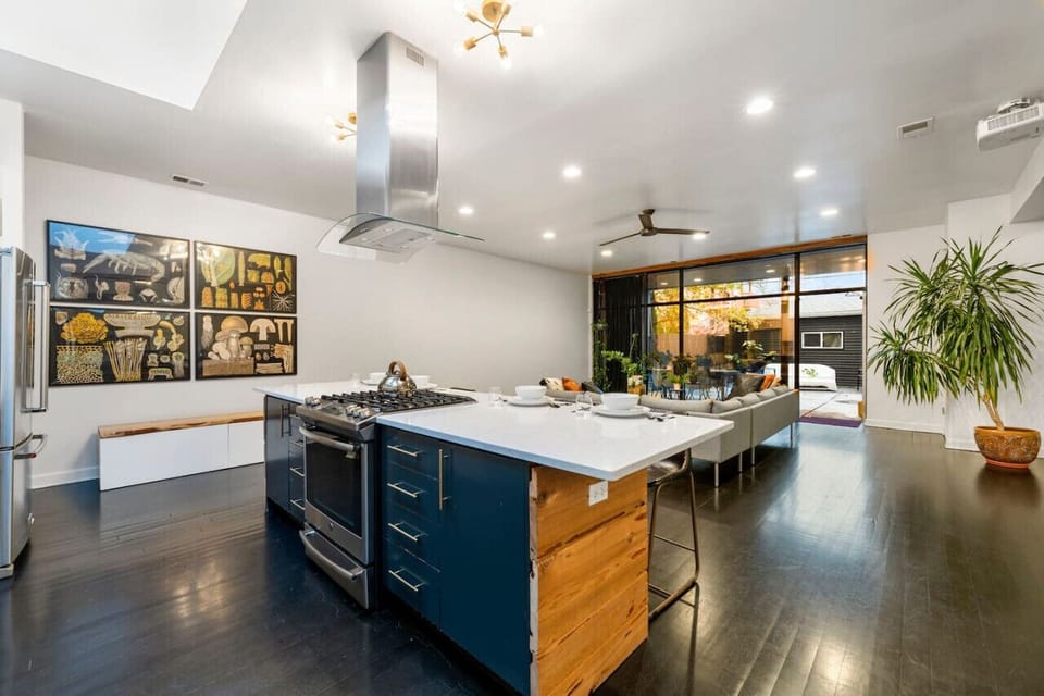 Open concept living, kitchen, and patio bathed in natural light. A serene space seamlessly connecting indoors and outdoors, framed by the beauty of nature.