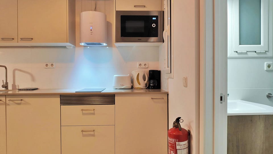 The compact and fully equipped open kitchen features modern appliances, perfect for preparing a quick breakfast before heading out to explore.