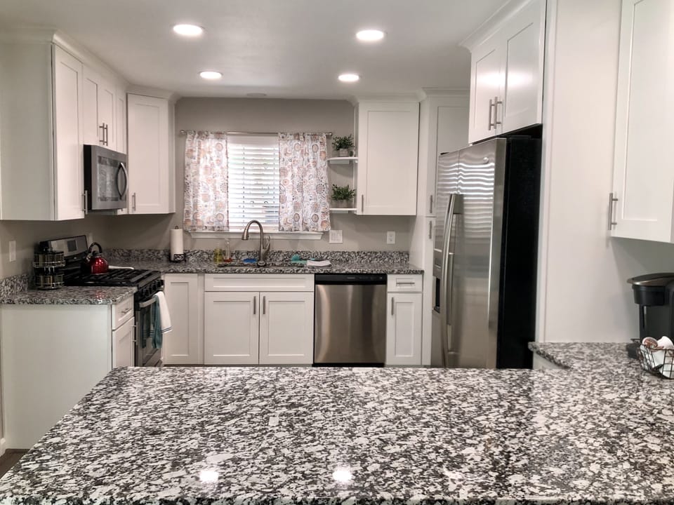 Kitchen with Stainless steel appliances, granite counters and bar that seats 4