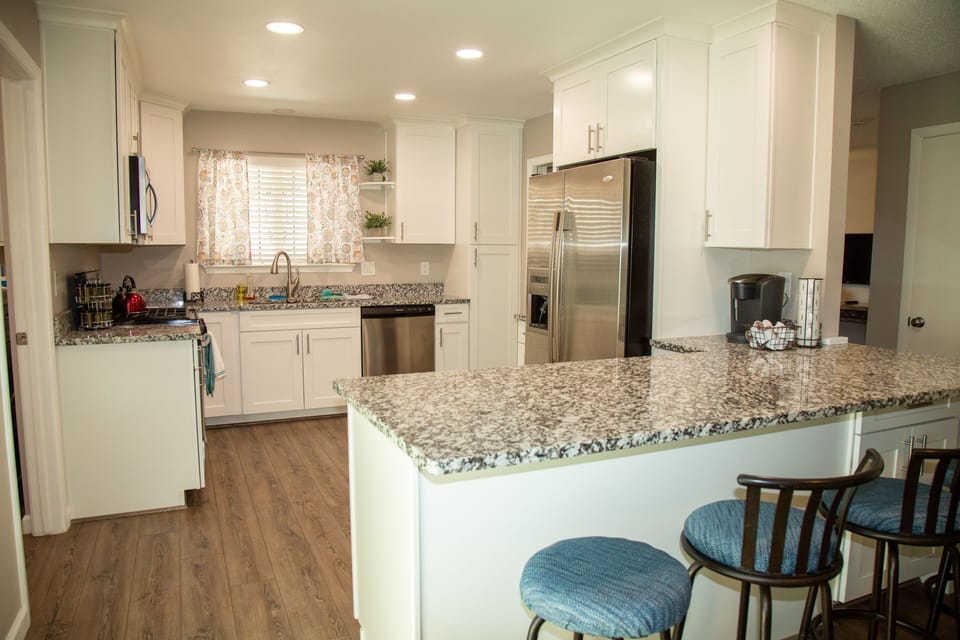 Kitchen with stainless steel appliances, granite countertops and bar seating