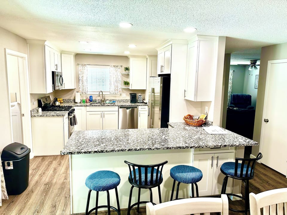 Large open kitchen with granite counters, stainless steel appliances & bar top