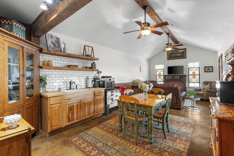 Share meals and laughter in the spacious barn kitchen and dining area with warm wooden beams.