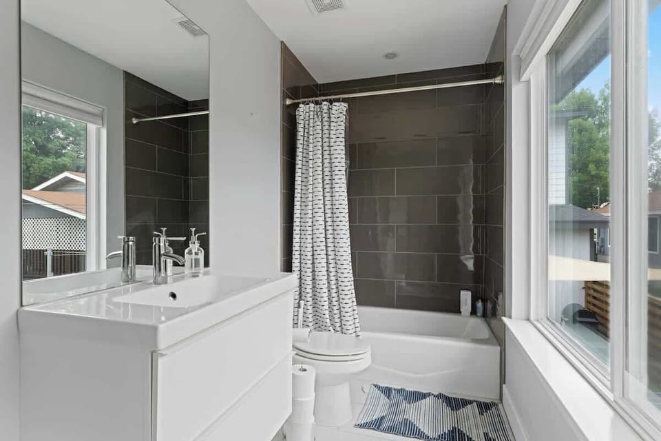 Bright, modern bathroom in this Austin, Florida retreat with sleek fixtures, a relaxing bathtub & tranquil views perfect for refreshing & recharging in Austin, Florida, at the heart of Austin, Florida living.