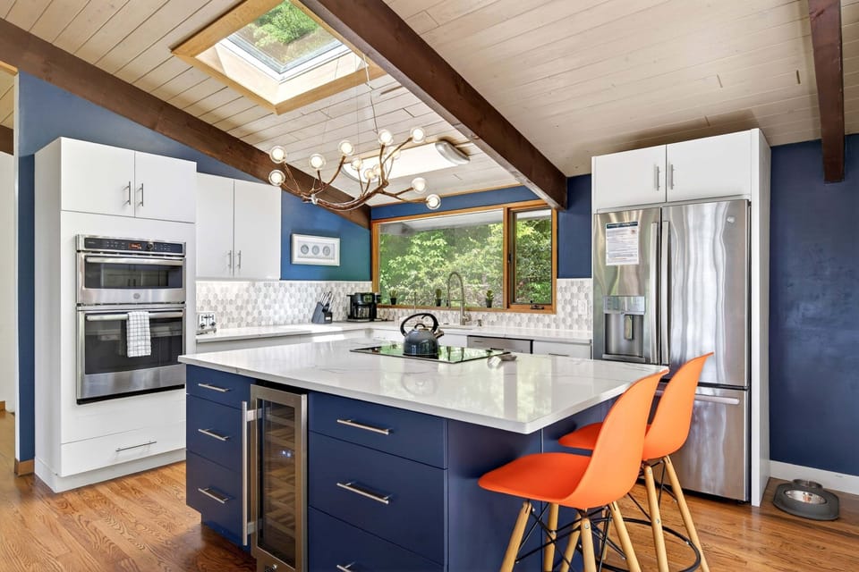 The gourmet GE kitchen offers double convection ovens, an induction cooktop, and a coffee station with a Keurig Duo, a Chemex pour-over with grinder and digital scale & beverage fridge.