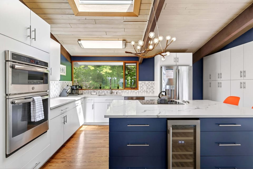The gourmet GE kitchen with a vaulted ceiling & skylight is perfect for morning waffles, Vitamix smoothies, and every meal in between