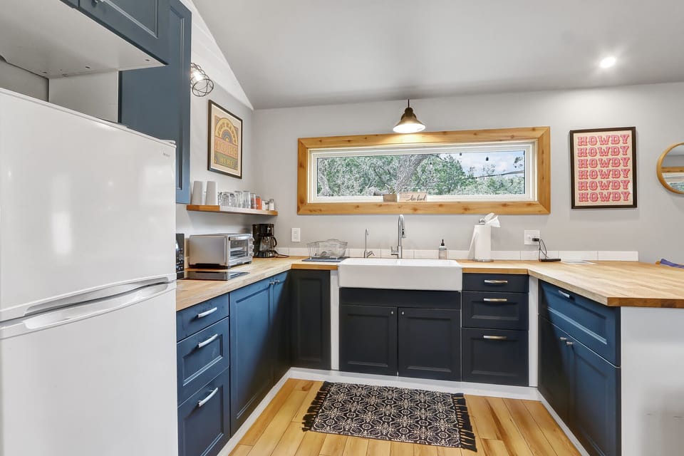 Kitchen area with refrigerator, coffee maker, microwave, and stove top