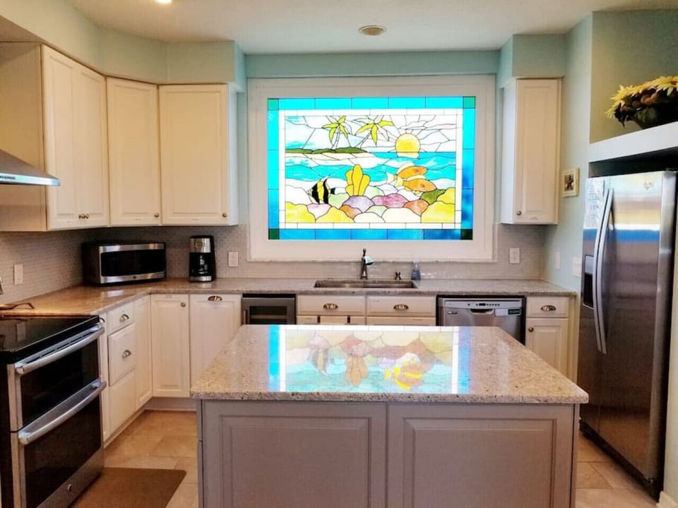 The sun shines through the stunning stained glass window in the kitchen