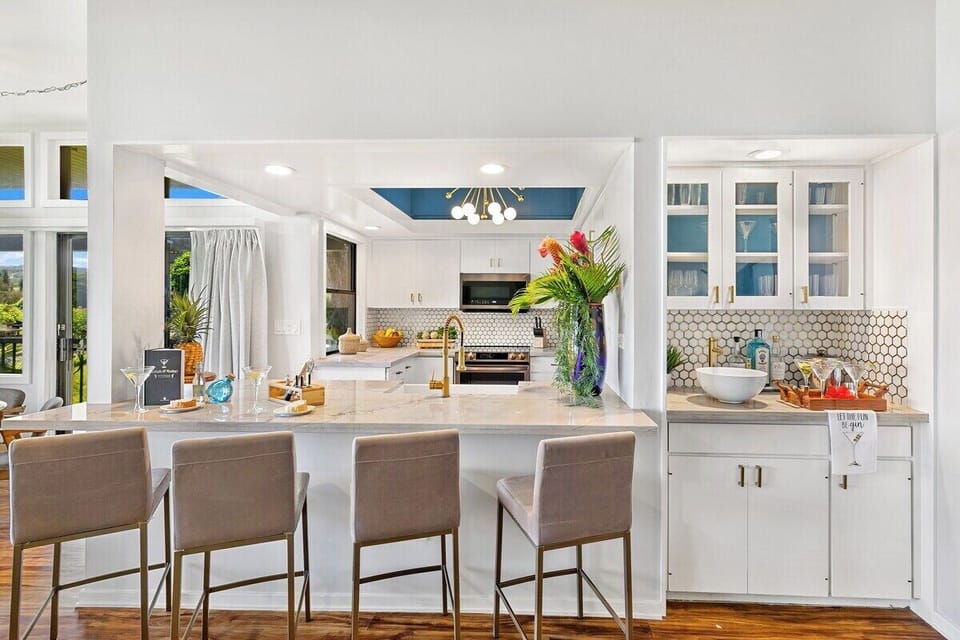 Kitchen island with bar seating, modern lighting, and open views to living space.