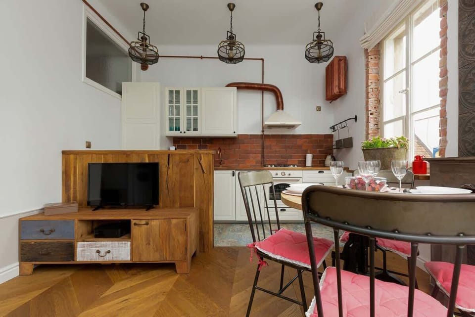 A relaxed living area with a vintage sofa, floral accents, and a dining table in the background, creating a versatile and welcoming space