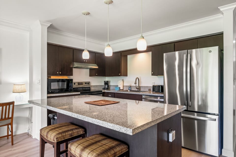 A granite island with bar seating, roomy enough for cooking elaborate island dinners or grabbing a quick bite before heading out the door.