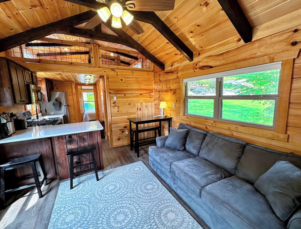 The main living space has a couch, TV, and gas fireplace with a table.