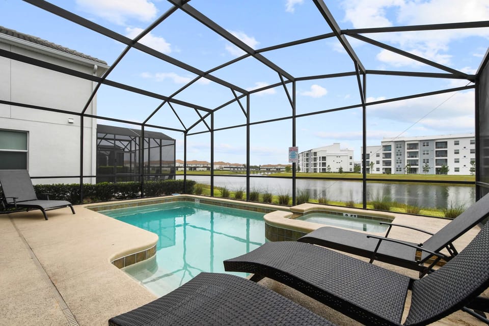 Relax by the private screened pool with serene lake views and comfy loungers.