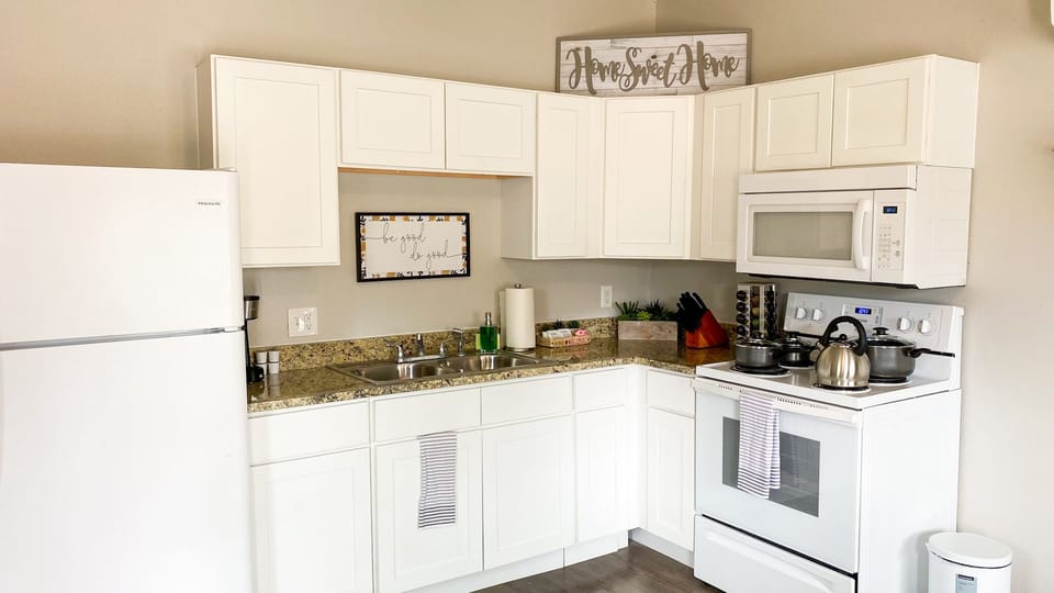 Fully stocked kitchen with pots, pans, and utensils.
