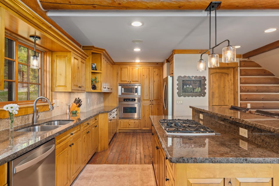 Step into your dream kitchen where rustic charm meets modern convenience! Rich wood cabinets and granite counters create the perfect space for cooking memorable meals while exposed beams overhead add that cozy cabin feel you'll love coming home to.