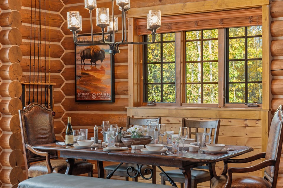 Step into your own rustic retreat where log walls and elegant lighting create the perfect setting for memorable dinners with loved ones, all while enjoying forest views.