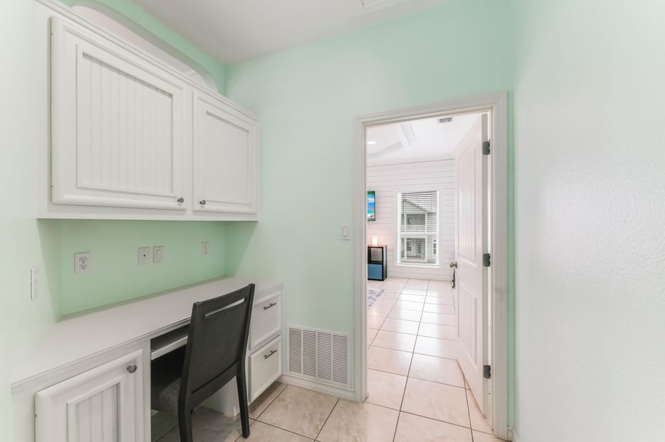 Your private workspace awaits with custom white cabinetry and built-in desk, perfect for productive mornings.