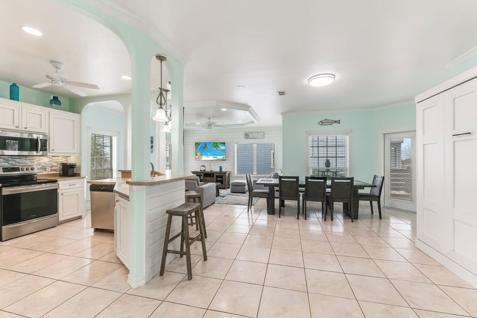 Your open-concept kitchen and dining area flows seamlessly with modern appliances, breakfast bar seating, and coastal-inspired decor for memorable meals together.