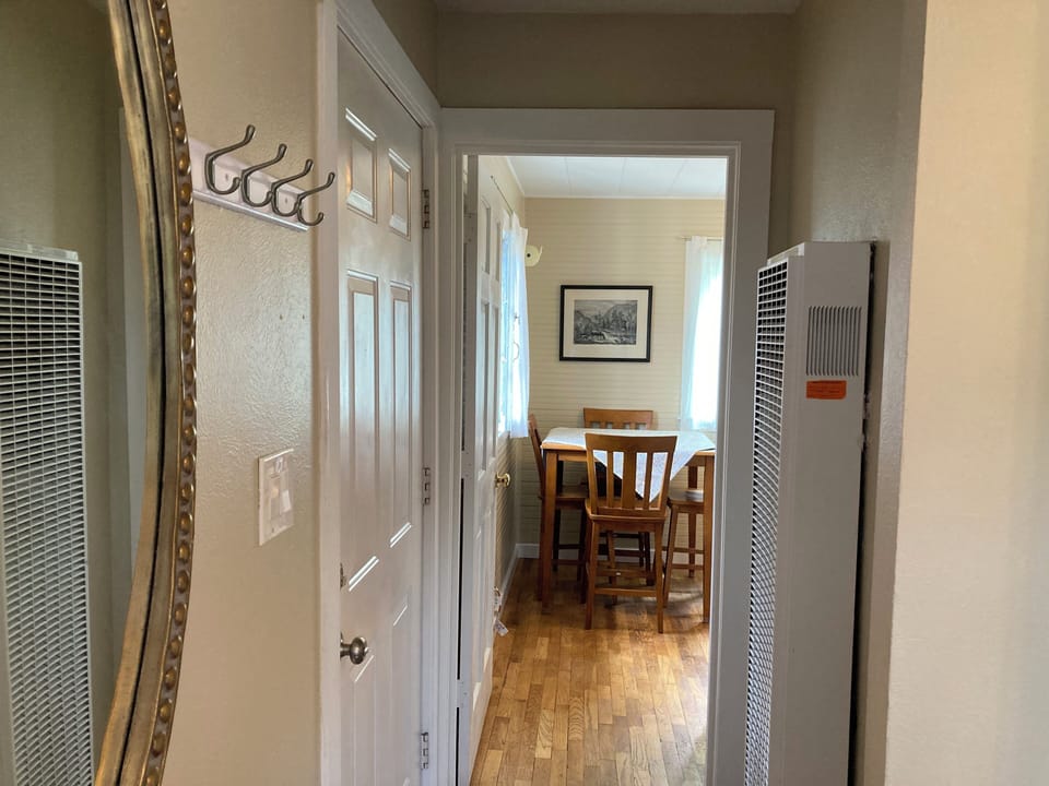 View into kitchen from living area. Front door on left.