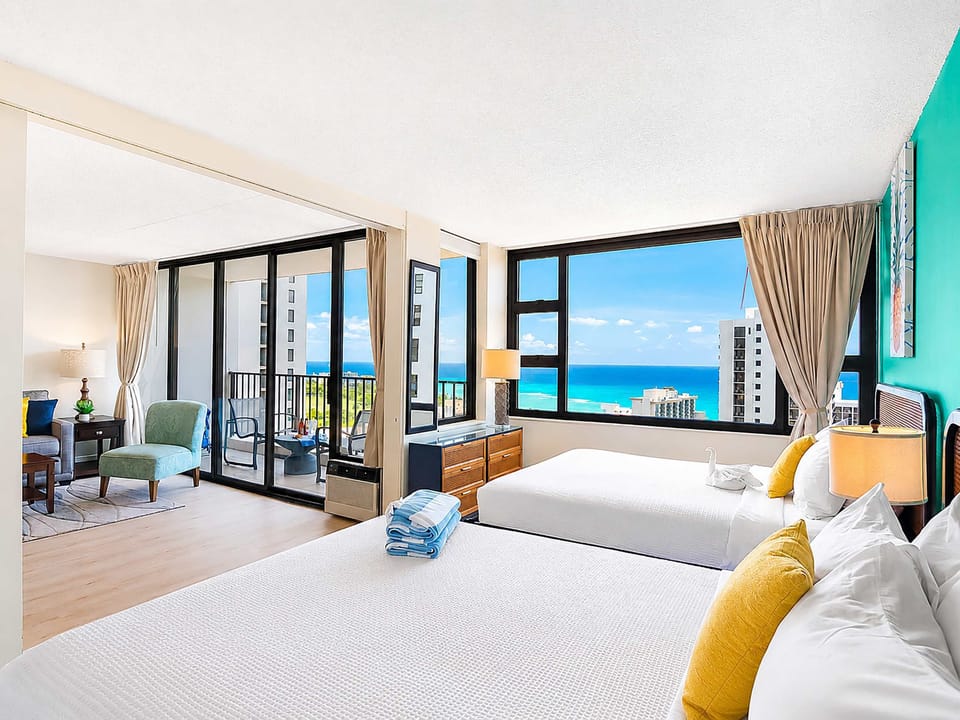 Bedroom with 2 Queen-size beds, nightstand, ocean view.