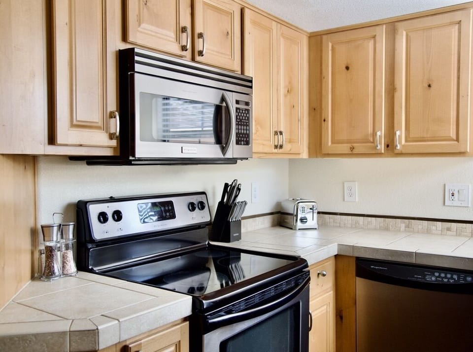 Kitchen includes fridge, electric stove, microwave, dishwasher and a toaster.