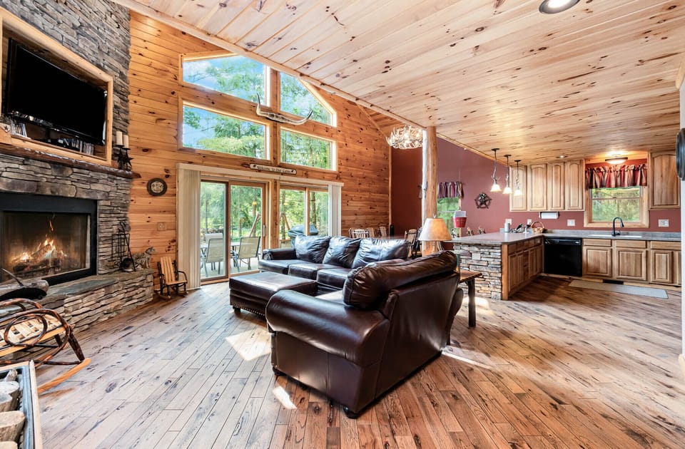 Open concept living, dining and kitchen area with door wall to deck and fire pit
