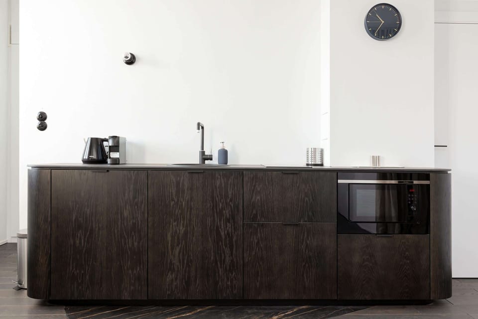 The sleek design of the kitchenette blending seamlessly with the living area.