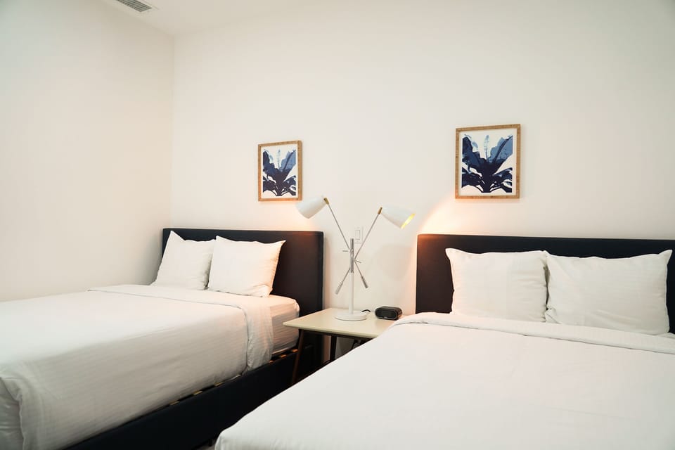 Crisp white linens and calming botanical art set the stage for your peaceful retreat with two plush beds awaiting your arrival.