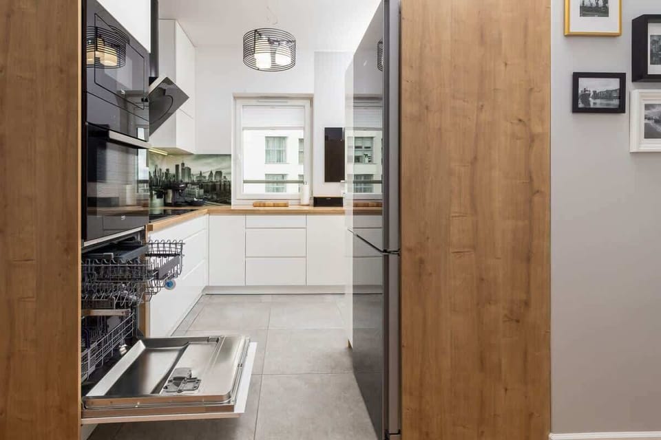  A close-up of a coffee station, complete with a coffee maker, cups, and neatly organized kitchen items on the countertop.