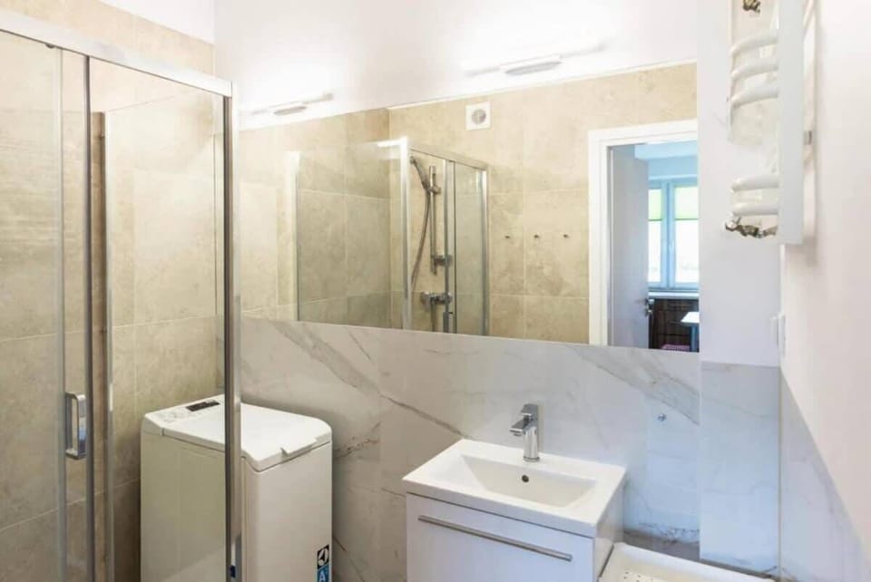 The bathroom's contemporary design includes fresh towels and a hairdryer. 