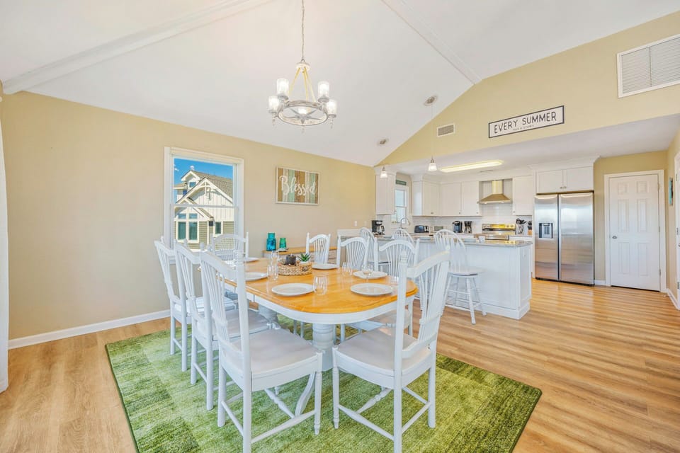 Gather around this welcoming dining space where your family can share meals under beautiful vaulted ceilings and cheerful coastal decor.