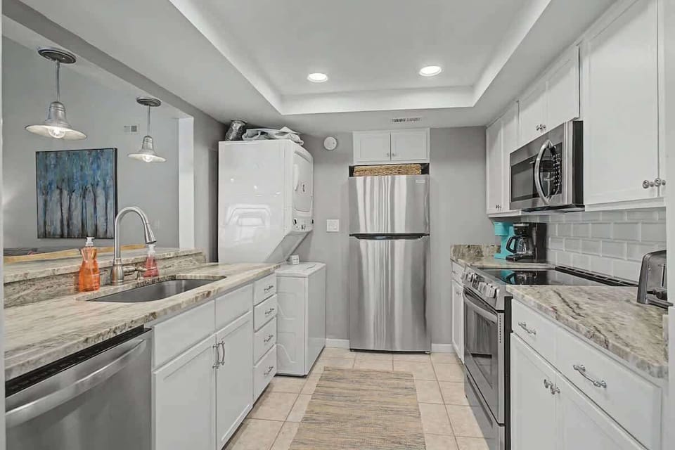 You'll love preparing meals in this stunning modern kitchen with granite countertops, stainless steel appliances, and elegant pendant lighting.