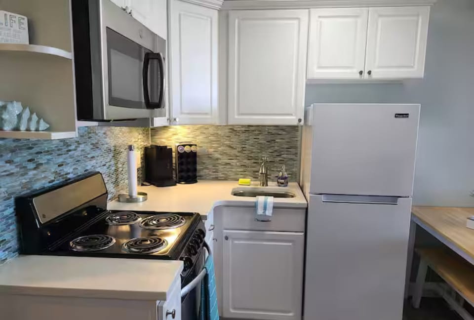 Updated kitchen with microwave, stove, and refrigerator