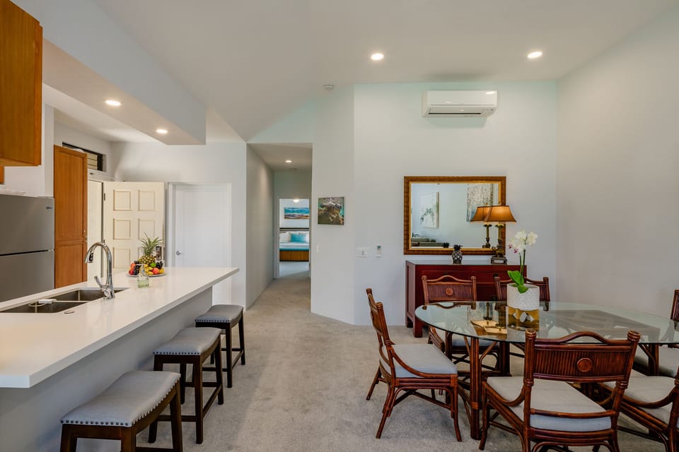 Dining area with glass table and breakfast bar seating